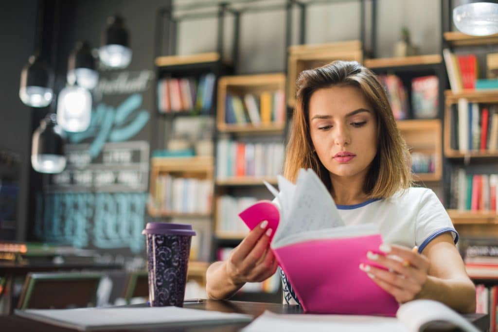 woman studies in the college library with student credit card expenses