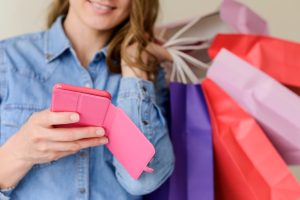 Woman using coupon apps while shopping.