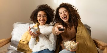 a couple of girls watching the best high school tv shows.