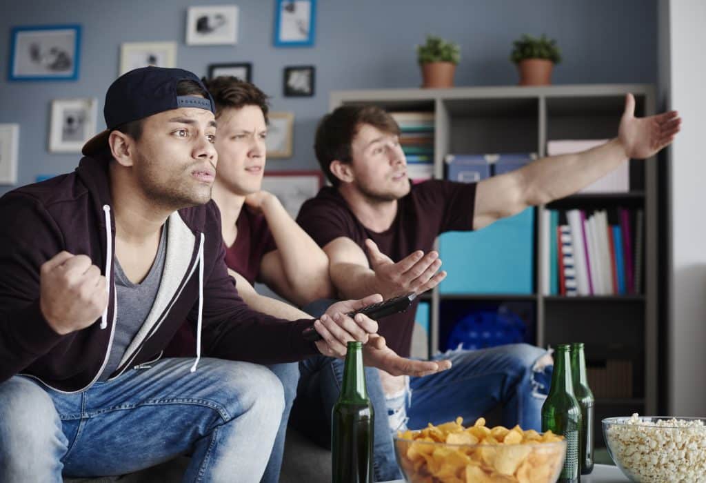 Friends reacting while watching a suspenseful crime television series